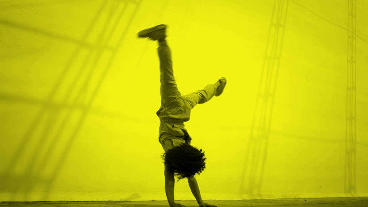 Breakdancer in a one-arm handstand, yellow duotone